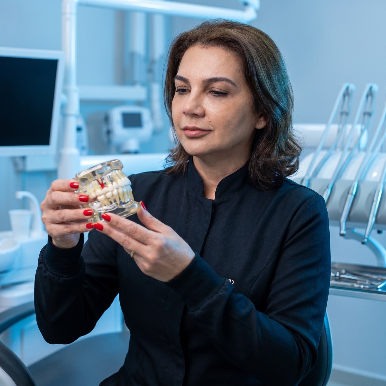 Dra. Ana Scatolin analisando um modelo de implante com atenção
