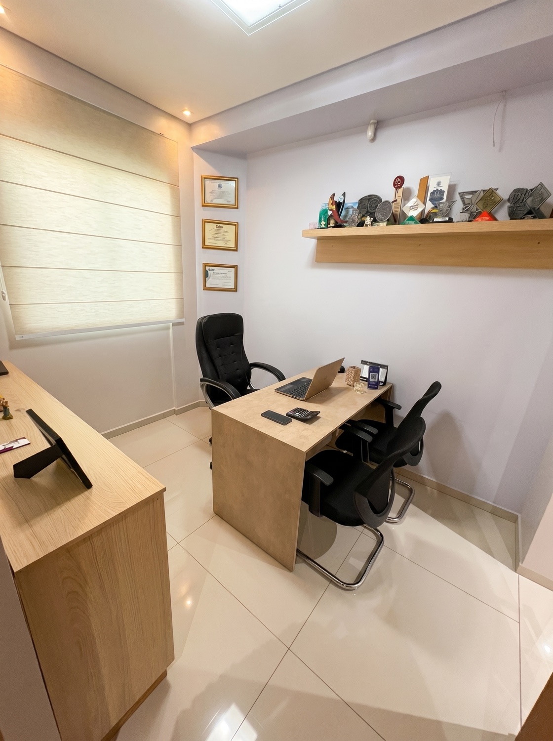 Sala de atendimento com diplomas e prêmios da Dra. Ana